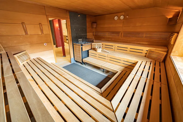 Holzverkleidete Sauna mit Sitzbänken und Saunaofen