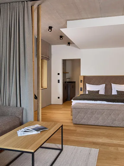 Hotelzimmer mit Doppelbett, Sofa und Holzeinrichtung
