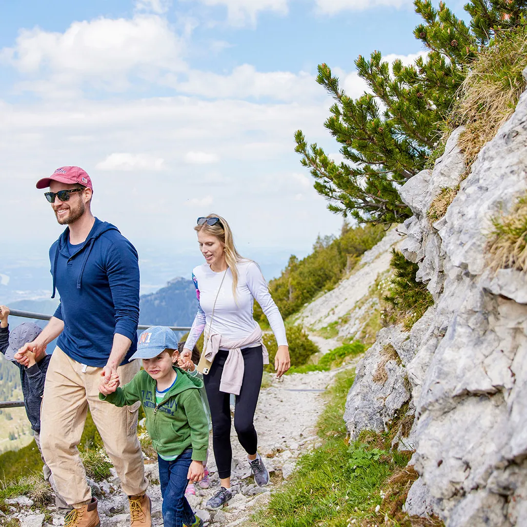 Familie mit Kindern wandert auf felsigem Bergpfad mit Weitblick
