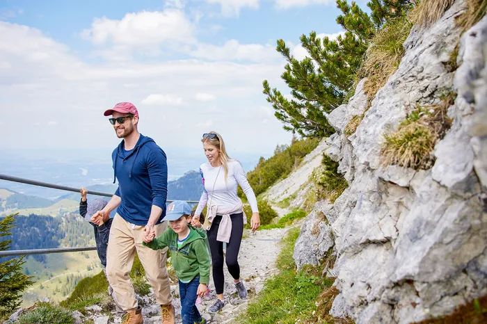 Familie mit Kindern wandert auf felsigem Bergpfad mit Weitblick