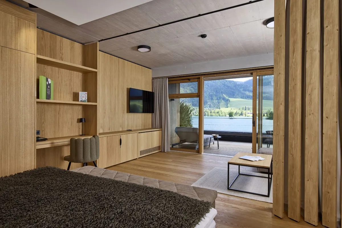 Hotelzimmer mit Holzverkleidung, Terrasse und Seeblick