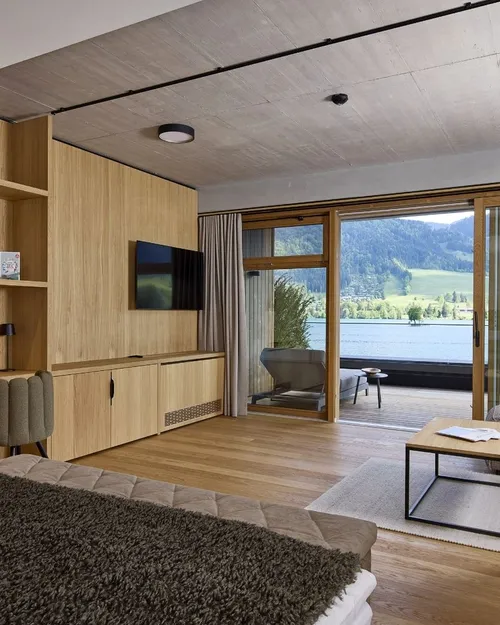 Hotelzimmer mit Holzverkleidung, Terrasse und Seeblick