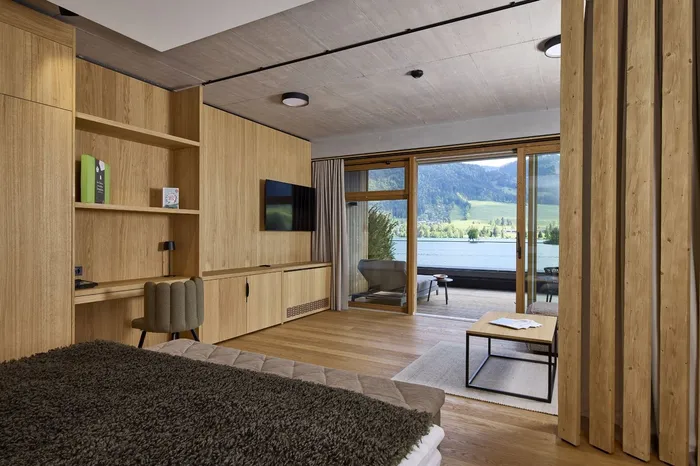 Hotelzimmer mit Holzverkleidung, Terrasse und Seeblick