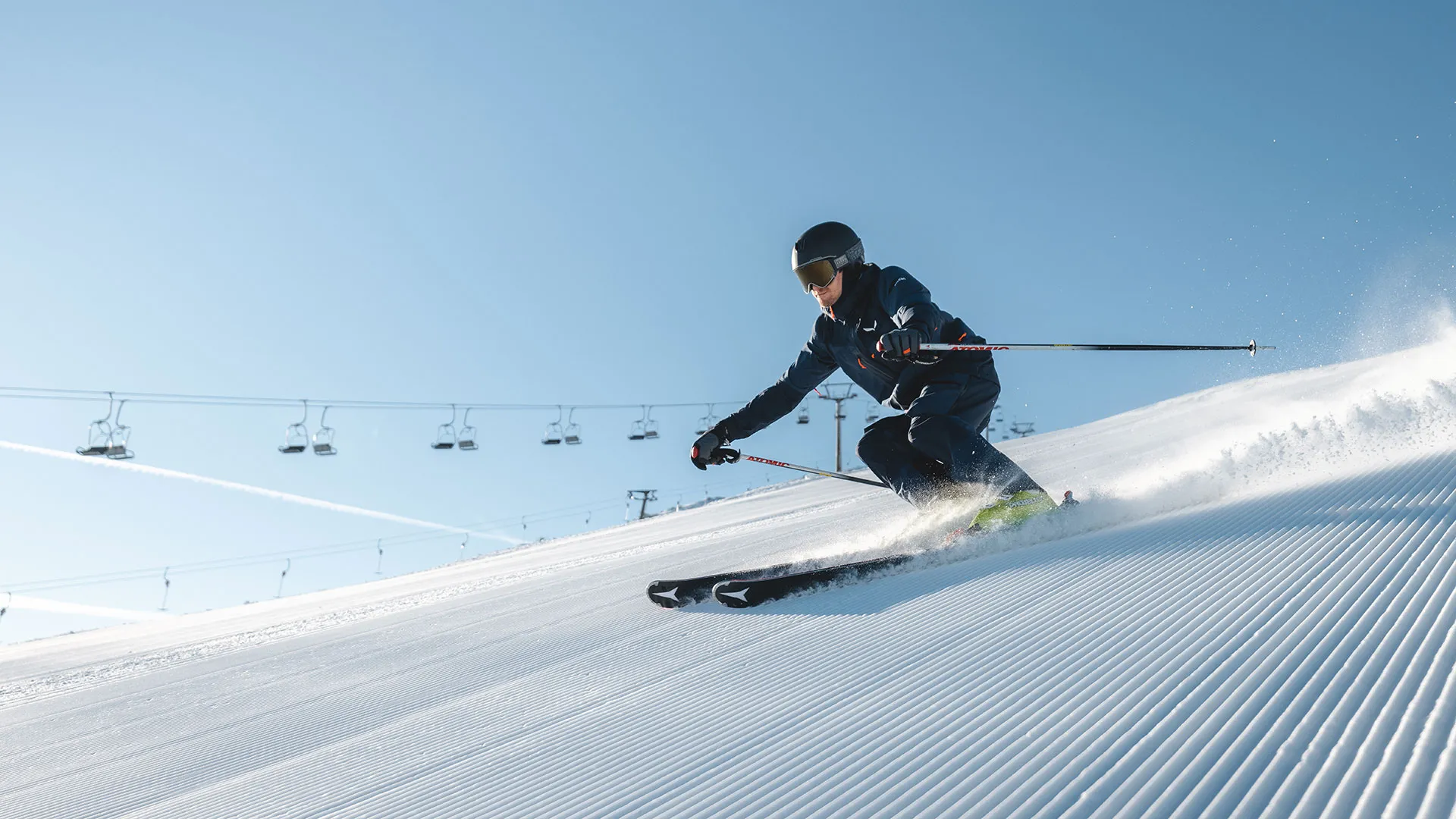 Skifahrer fährt auf frisch präparierter Piste bei Sonnenschein