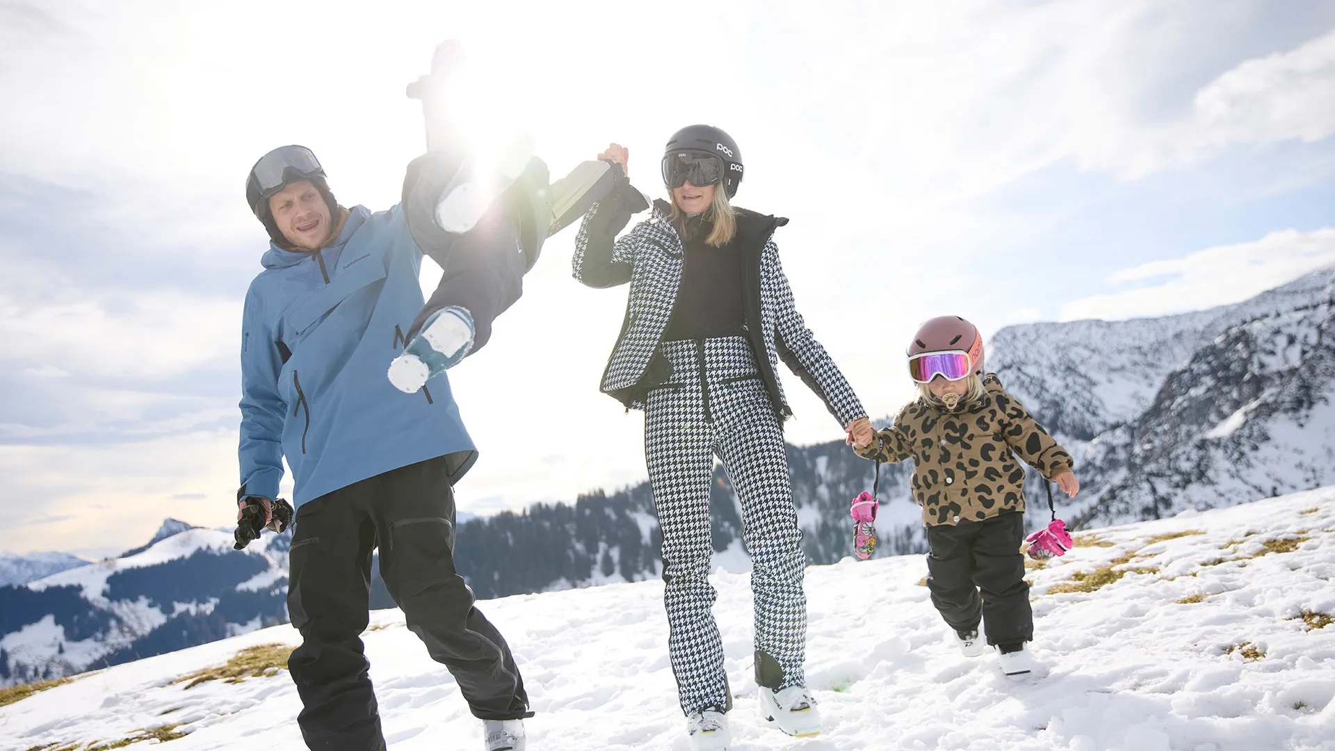 Familie mit Kindern in Skibekleidung wandert durch den Schnee in den Bergen