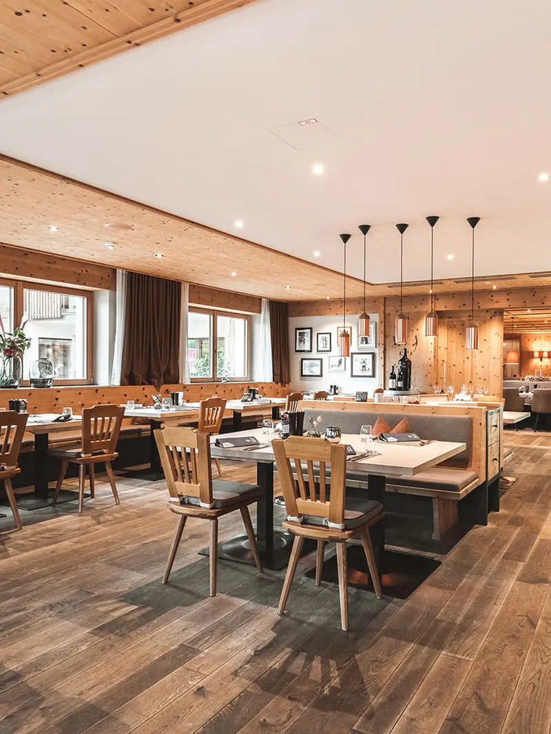 Restaurant mit Holzverkleidung, gedeckten Tischen und Holzstühlen