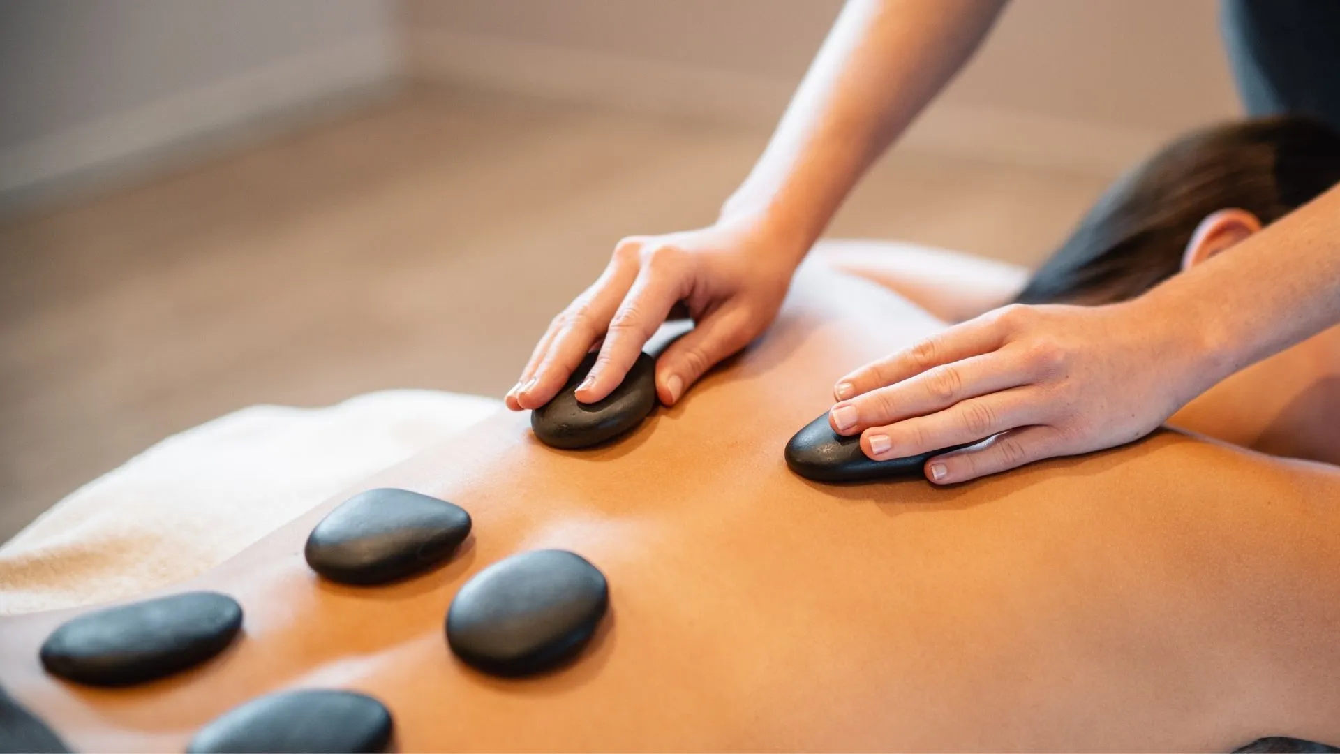 Hot-Stone-Massage mit warmen Steinen auf dem Rücken