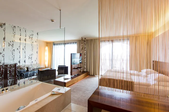 Suite mit freistehender Badewanne, Fadenvorhang und Doppelbett