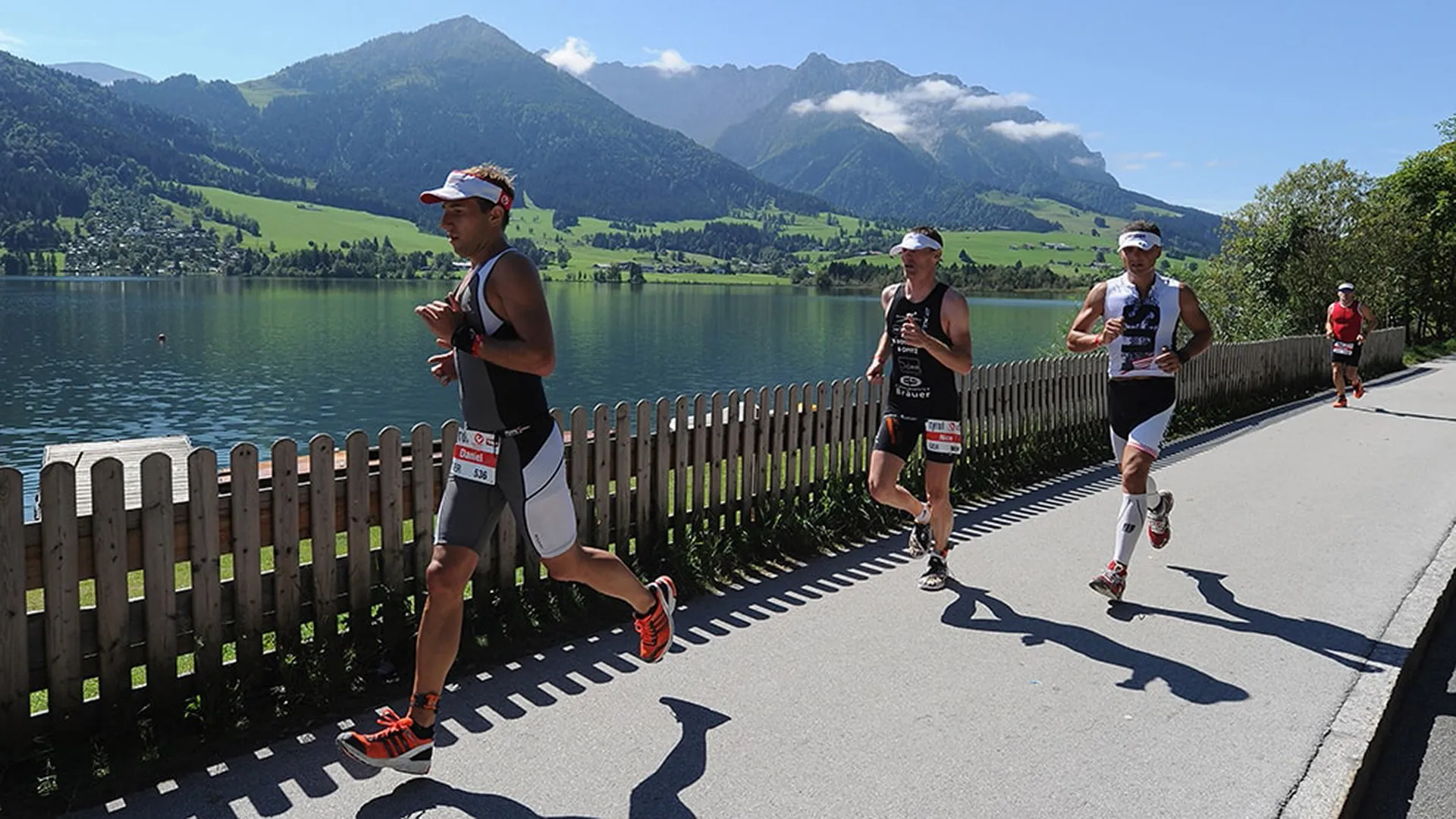 Läufer beim Triathlon am Ufer des Walchsees mit Bergpanorama