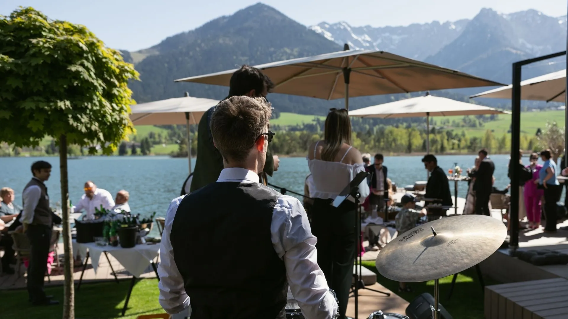 Live-Band spielt bei Feier am See mit Blick auf Berge