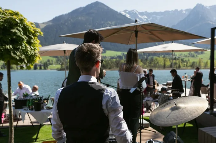 Live-Band spielt bei Feier am See mit Blick auf Berge