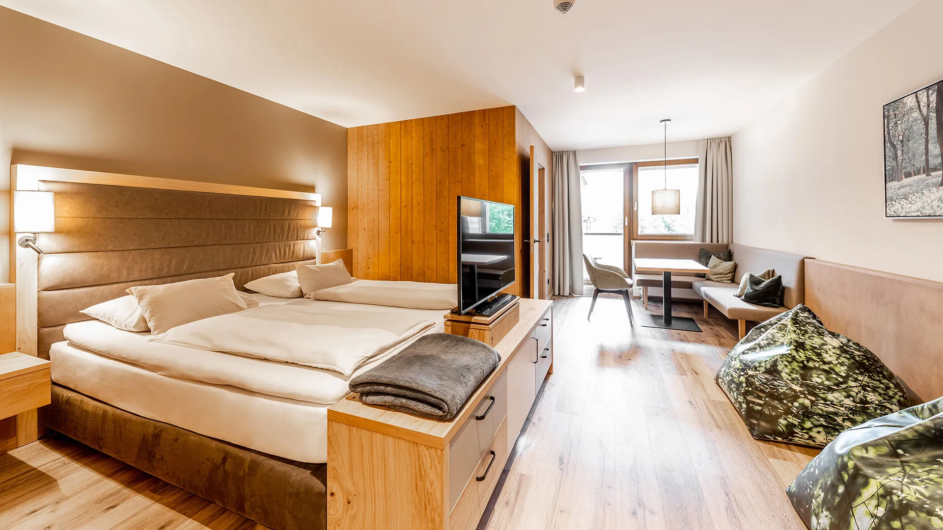 Hotelzimmer mit Doppelbett, Sitzecke und Holzboden