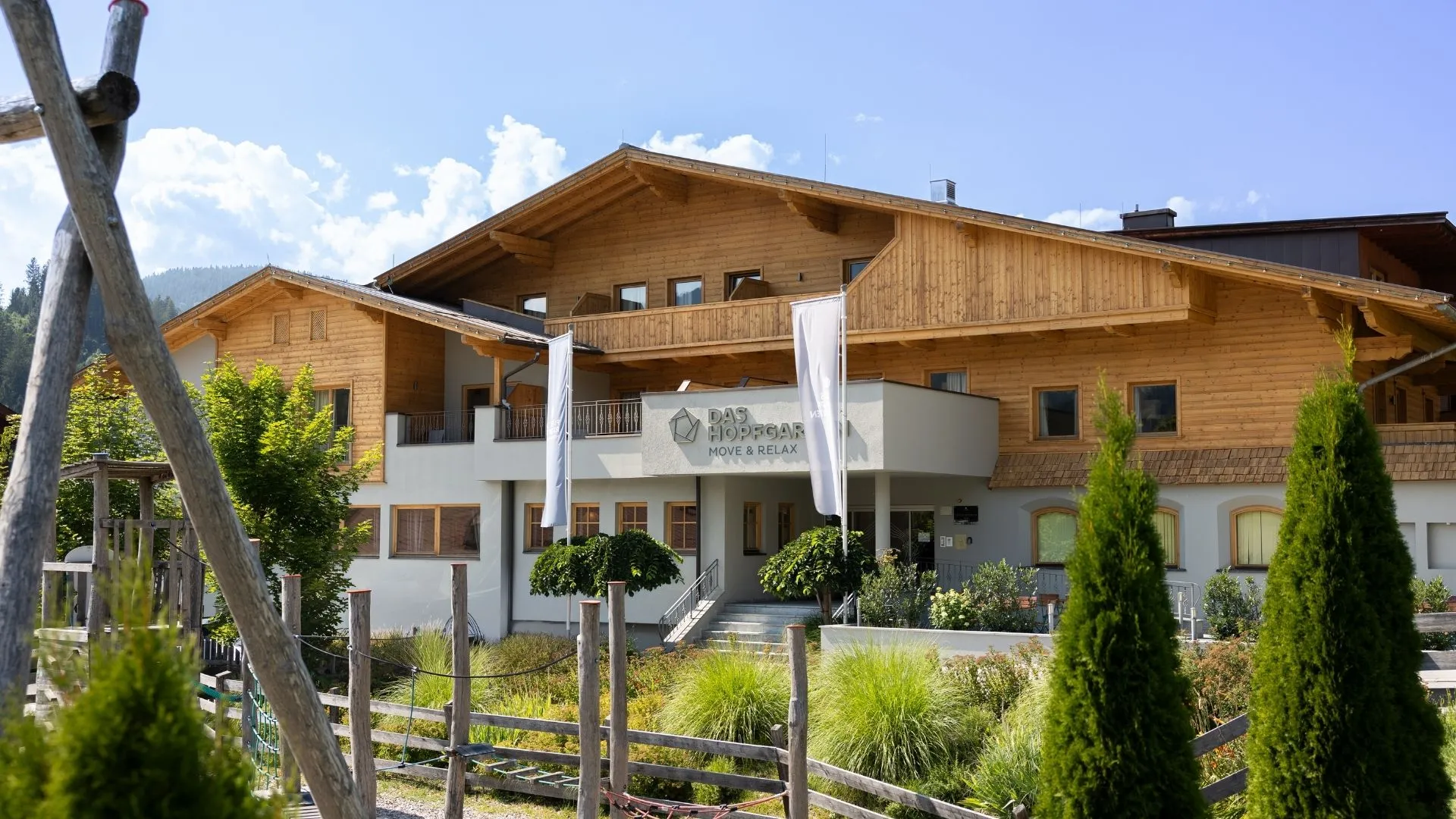 Außenansicht des Hotels Das Hopfgarten mit Holzfassade und Garten