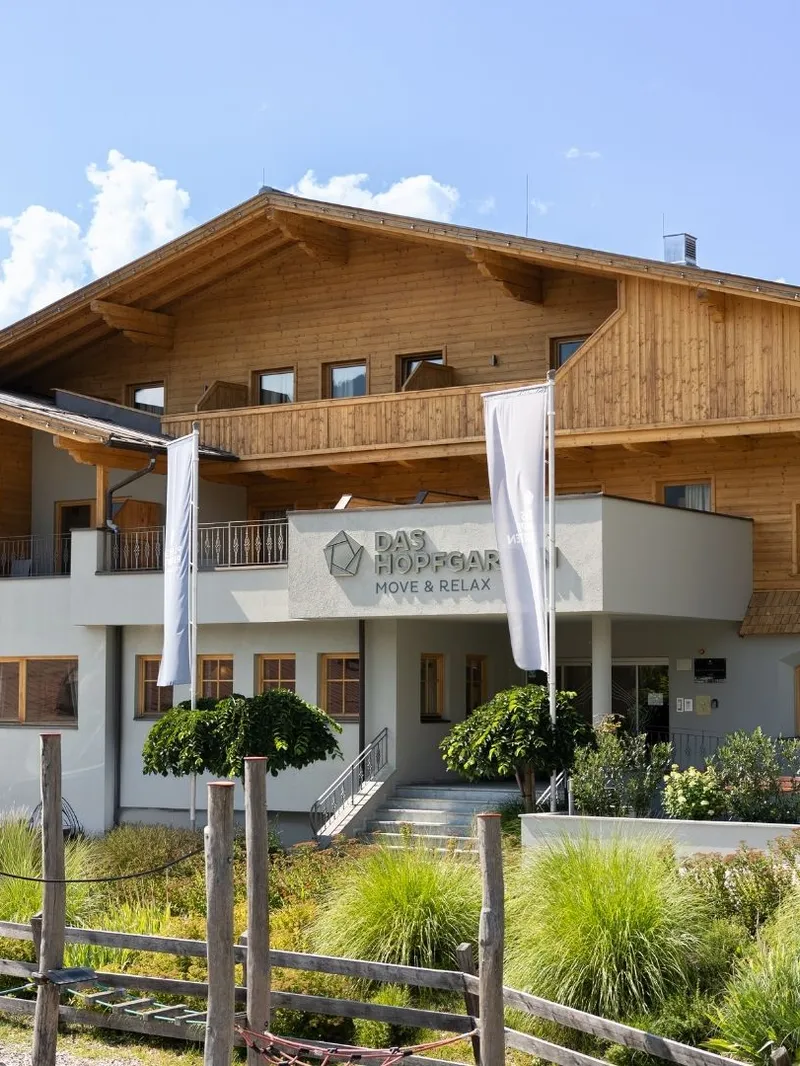 Außenansicht des Hotels Das Hopfgarten mit Holzfassade und Garten
