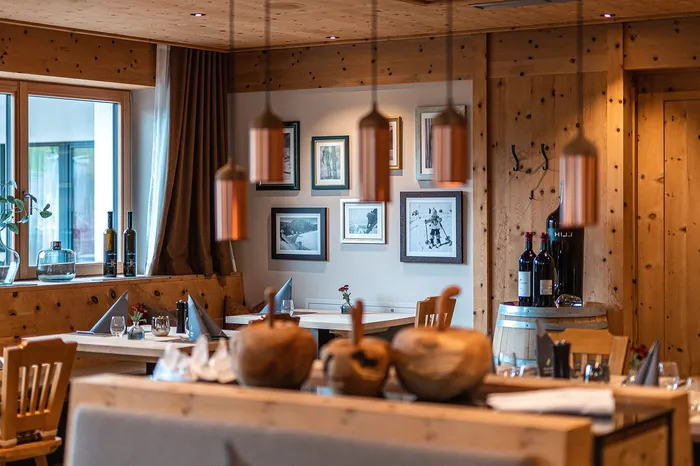 Rustikales Restaurant mit Holzvertäfelung, gedeckten Tischen und Bildern an der Wand