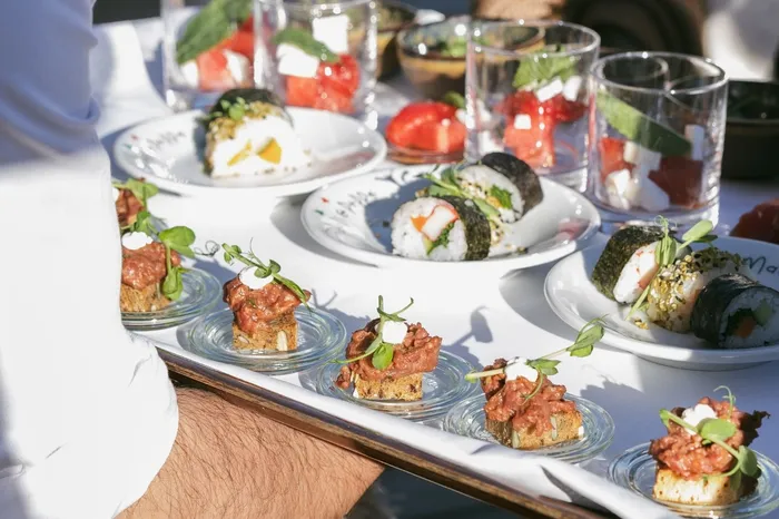 Kellner serviert Sushi und Fingerfood auf Tablett bei Veranstaltung