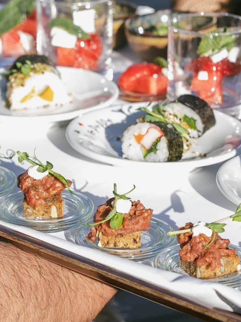 Kellner serviert Sushi und Fingerfood auf Tablett bei Veranstaltung