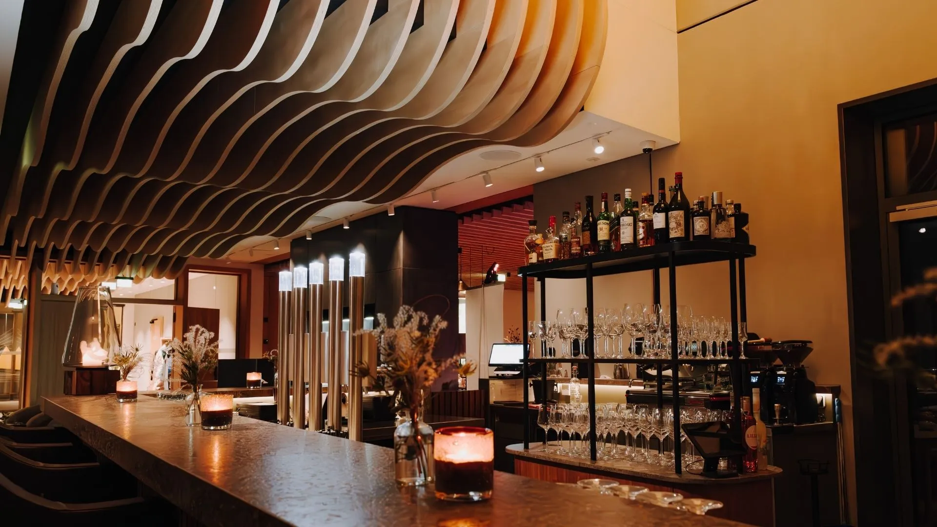 Hotelbar mit Kerzen, Weingläsern und Spirituosenregal