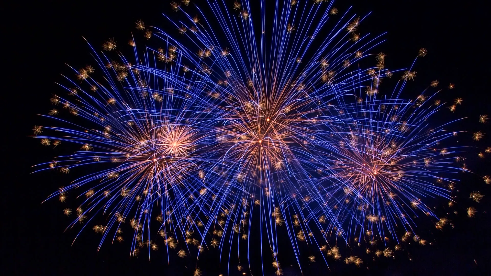 Blaues Feuerwerk mit mehreren Explosionen am Nachthimmel