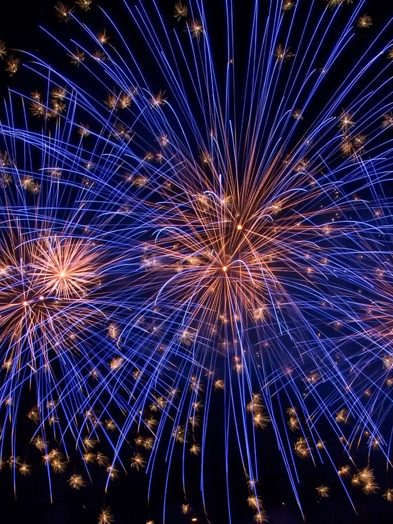 Blaues Feuerwerk mit mehreren Explosionen am Nachthimmel