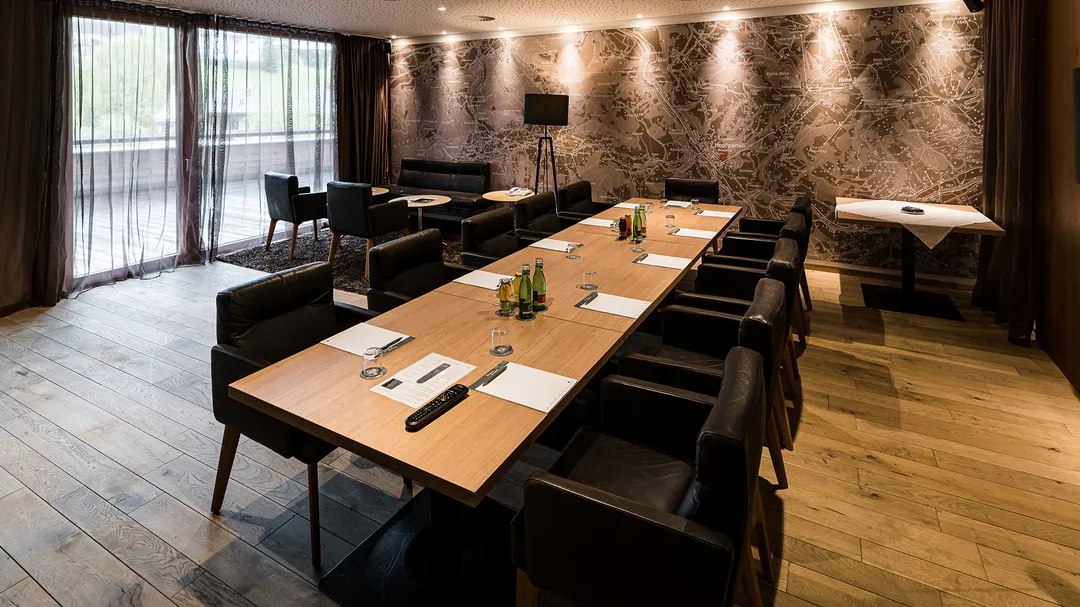 Seminarraum mit langem Konferenztisch, Lederstühlen und Landkarten-Tapete