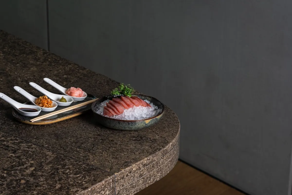 Thunfisch-Sashimi auf Eis mit Beilagen und Sojasauce auf Steintisch