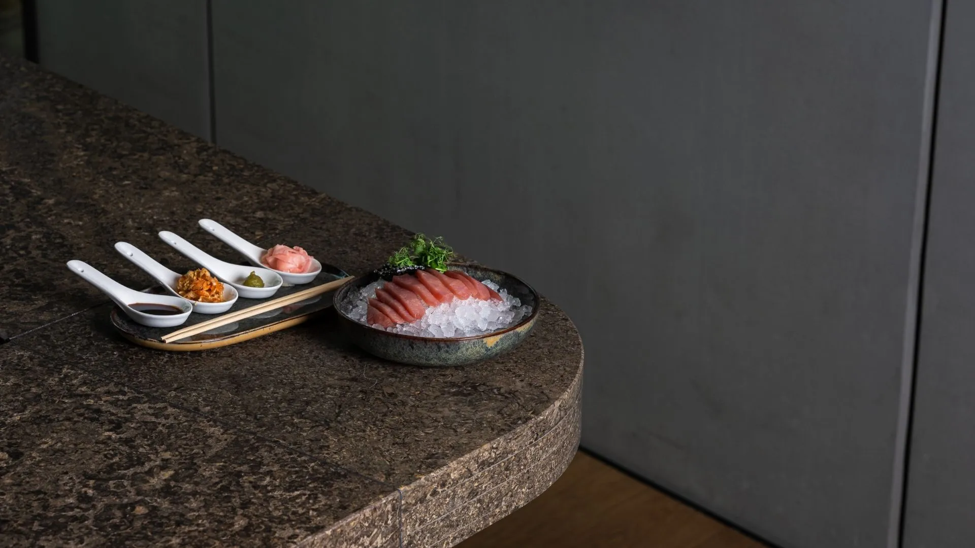 Thunfisch-Sashimi auf Eis mit Beilagen und Sojasauce auf Steintisch