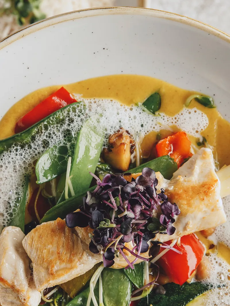 Fischgericht mit Gemüse, Kokosschaum und Kresse in Currysauce
