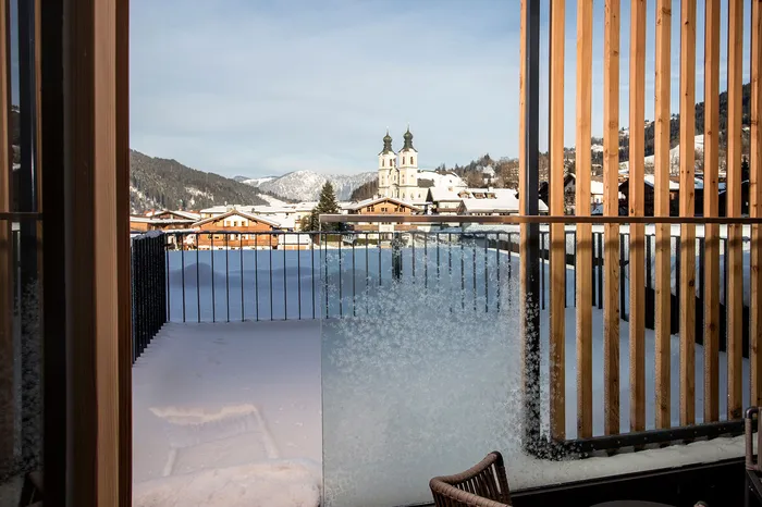 Schneebedeckter Balkon mit Blick auf Kirche und Ort im Winter
