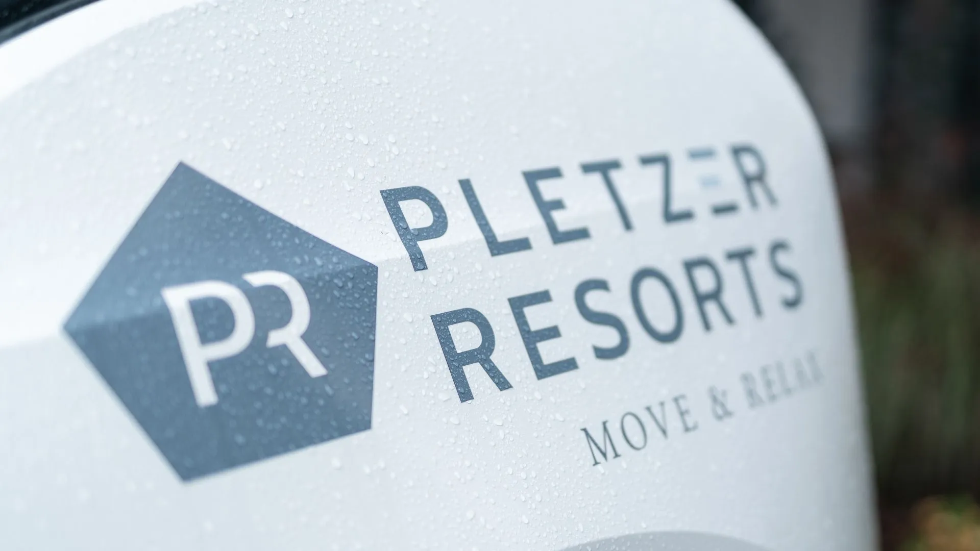 Pletzer Resorts Logo mit Regentropfen auf weißer Fläche