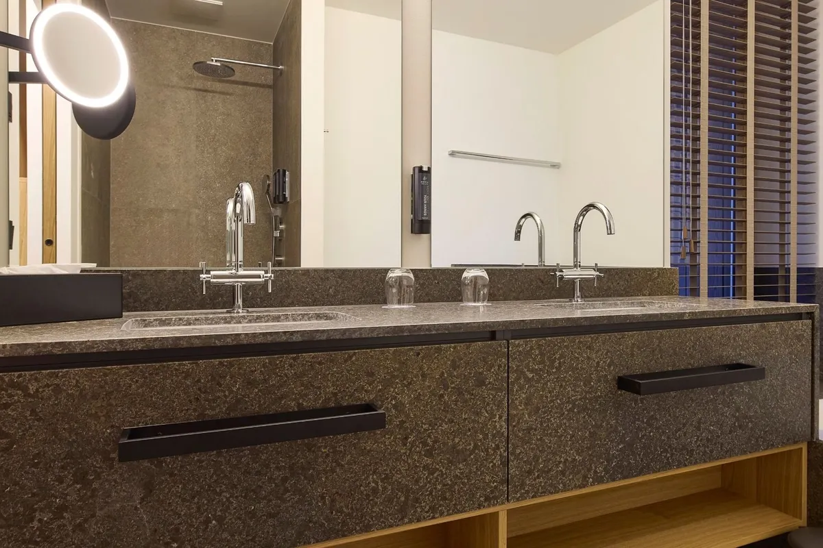 Doppelwaschtisch aus Naturstein mit Spiegel und Badewanne in der Suite