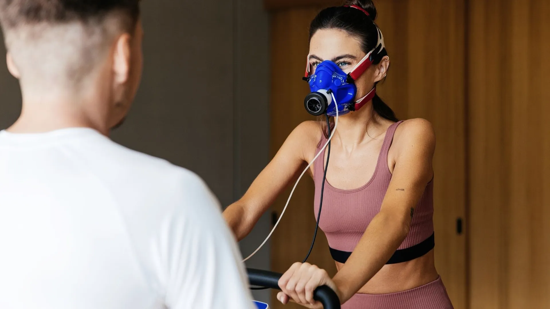 Frau mit Atemmaske bei Spiroergometrie-Test auf Trainingsgerät