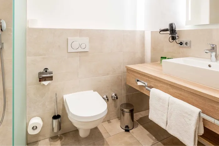 Modernes Hotelbadezimmer mit Waschtisch, WC und Dusche