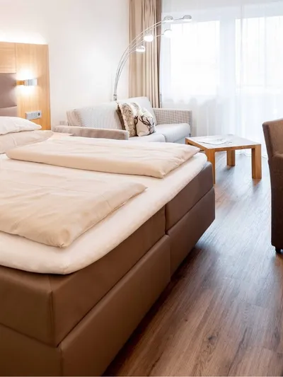 Hotelzimmer mit Doppelbett, Sitzecke und Bademänteln