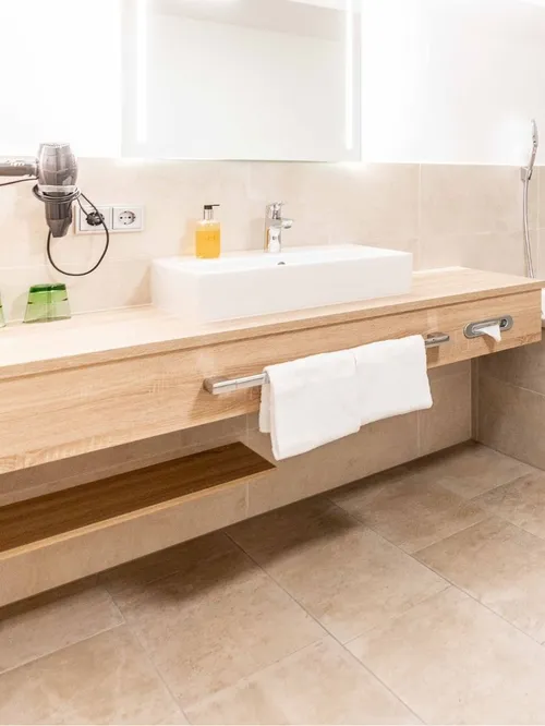 Modernes Badezimmer mit Badewanne, Waschtisch und Handtuchheizkörper
