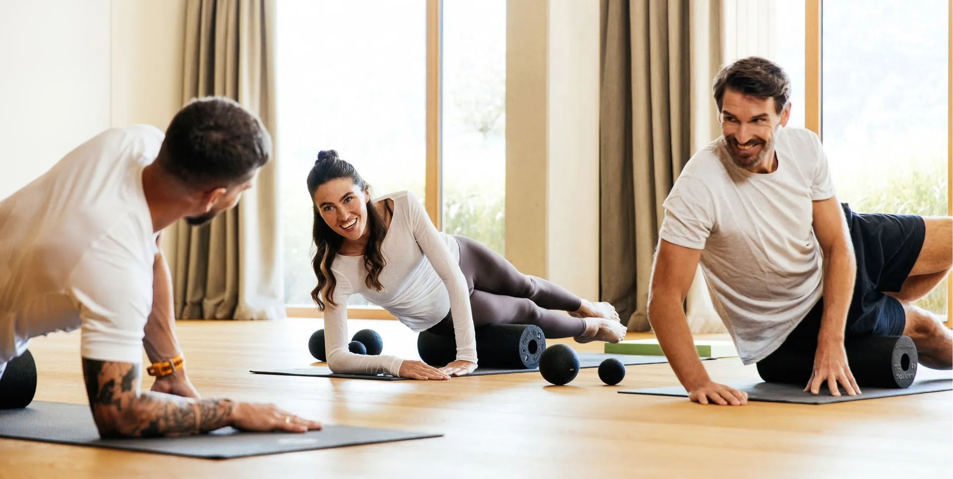 Gruppe trainiert mit Faszienrollen im Fitnessraum
