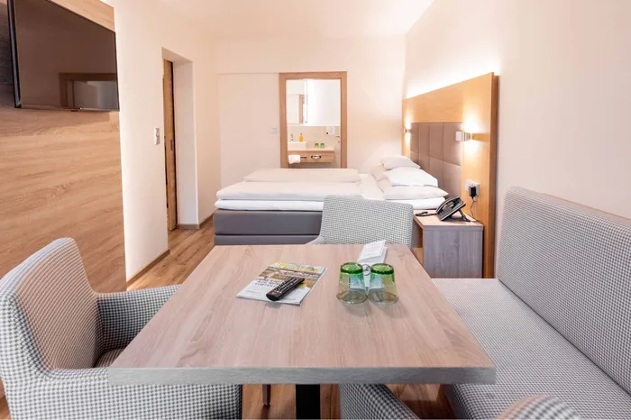 Hotelzimmer mit Doppelbett, Sitzecke und Tisch