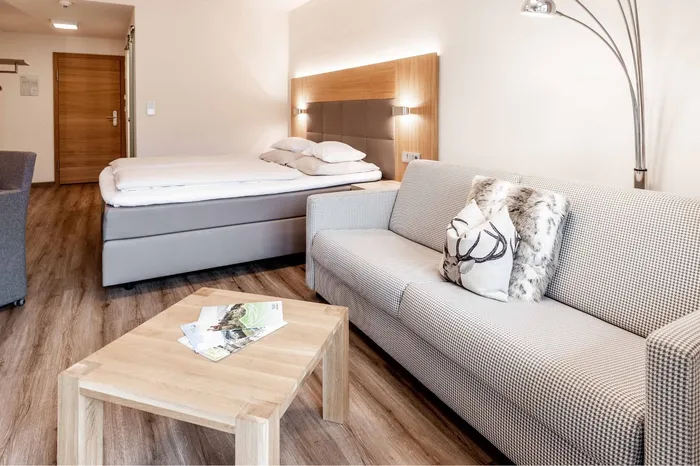 Hotelzimmer mit Doppelbett, Sofa und Couchtisch