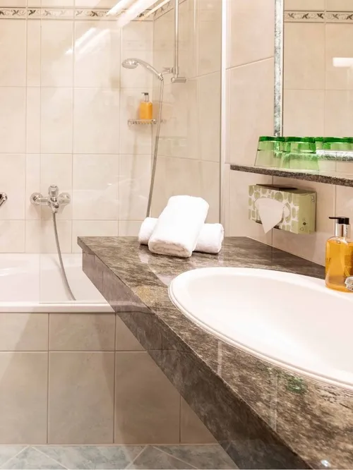 Badezimmer mit Badewanne, Handtüchern und Waschbecken