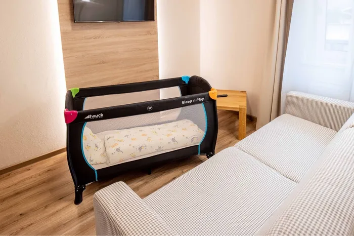 Reisebett neben Sofa im Familienzimmer