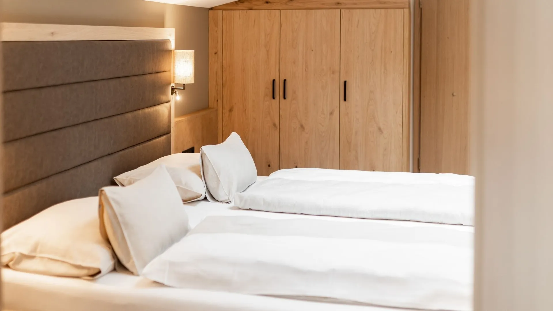 Doppelbett mit Holzschrank im Hotelzimmer