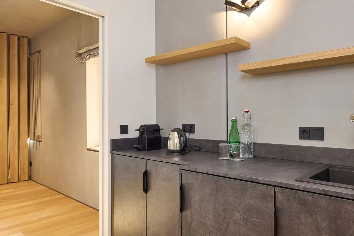 Kitchenette in Suite mit Wasserkocher, Kaffeemaschine und Blick in den Schrankraum