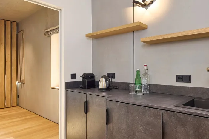 Kitchenette in Suite mit Wasserkocher, Kaffeemaschine und Blick in den Schrankraum