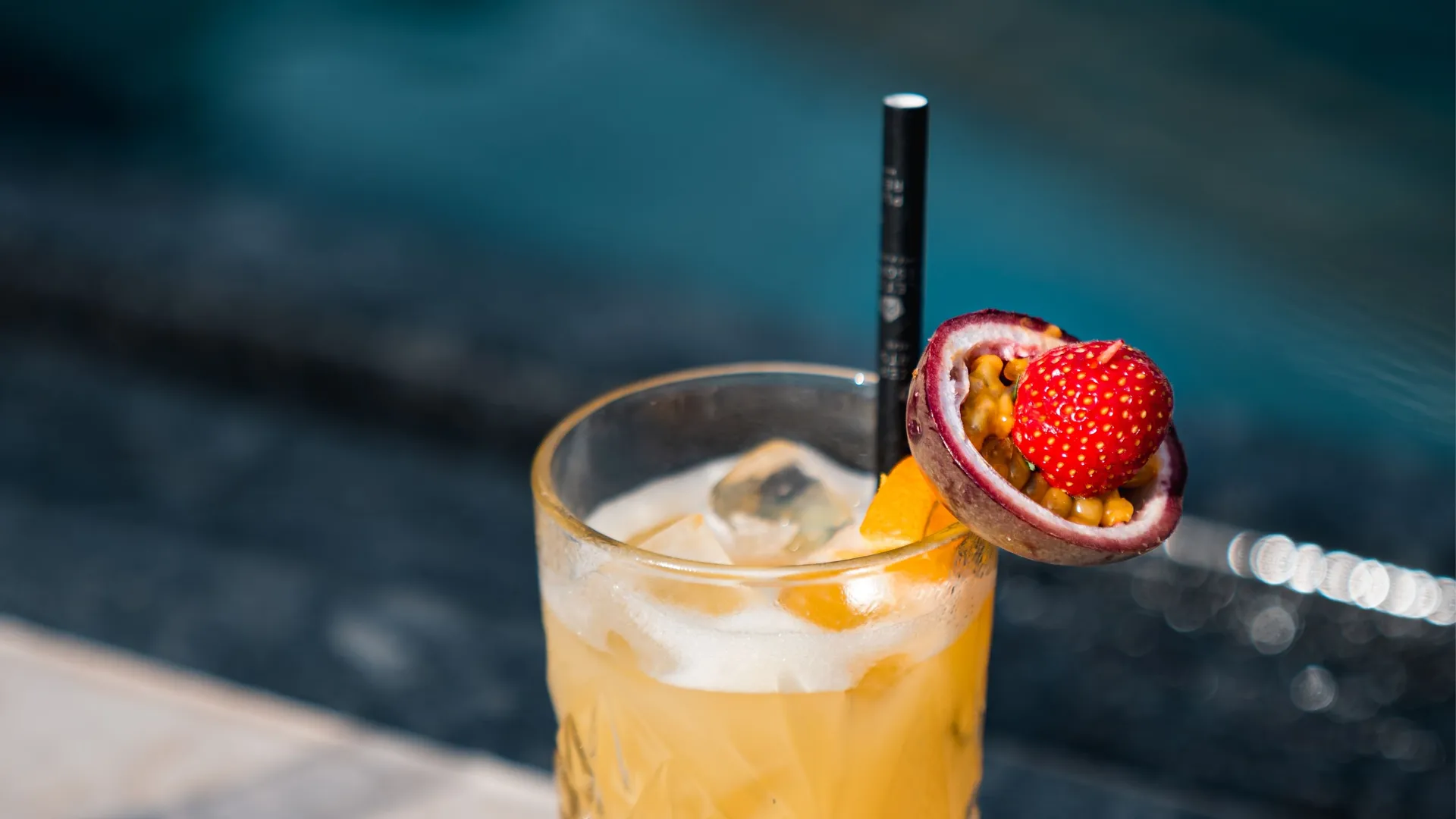 Fruchtiger Cocktail mit Maracuja und Erdbeere am Pool