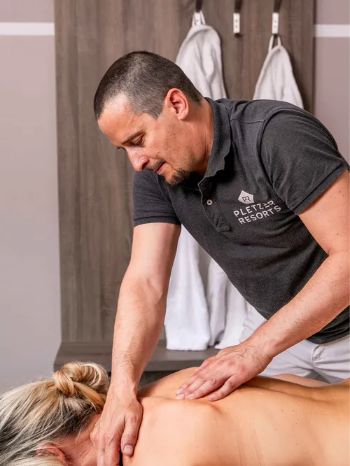 Masseur behandelt Rücken einer Frau im Spa