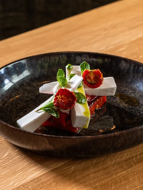 Vorspeise mit Feta, gerösteter Paprika und Minze auf dunklem Teller