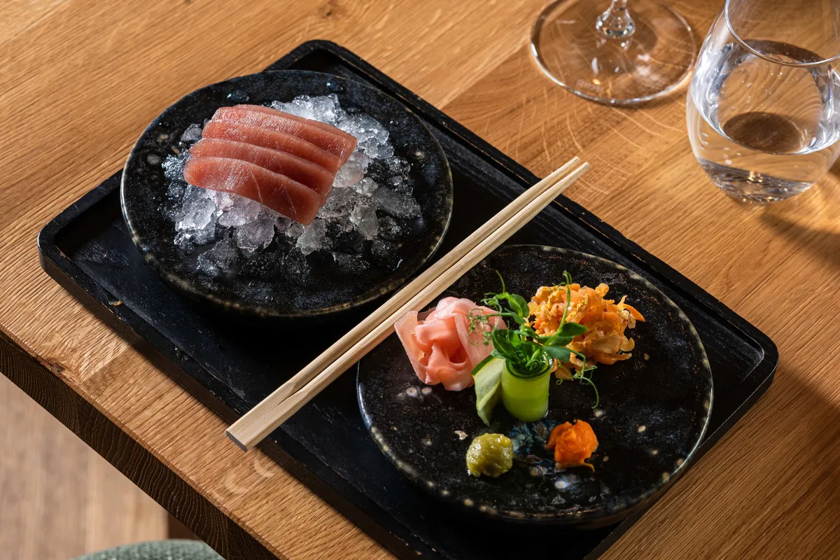 Thunfisch-Sashimi auf Eis mit Ingwer, Wasabi und Beilagen serviert