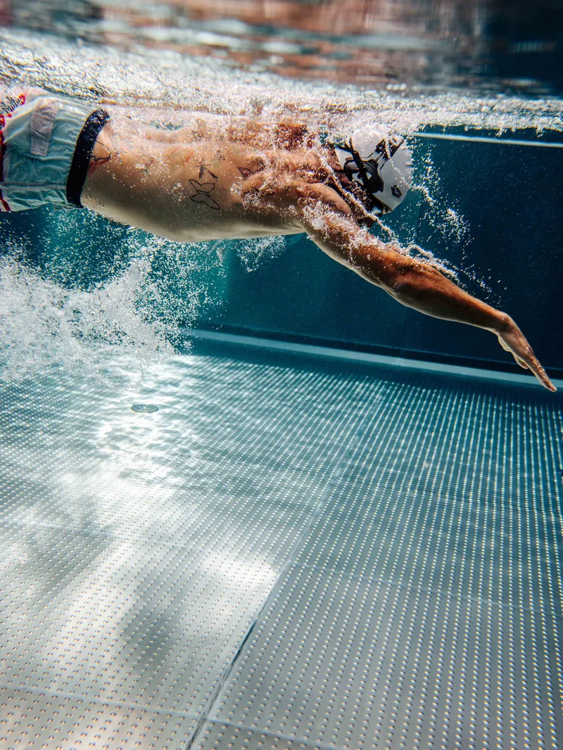 Schwimmer taucht unter Wasser im Pool