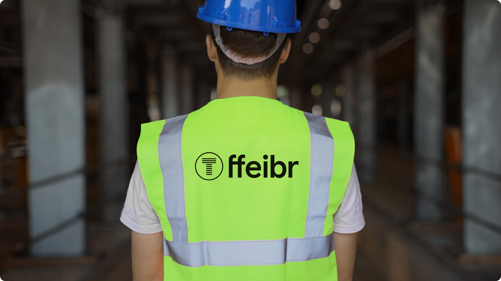 A ffeibr engineer in a branded hi-vis vest on site