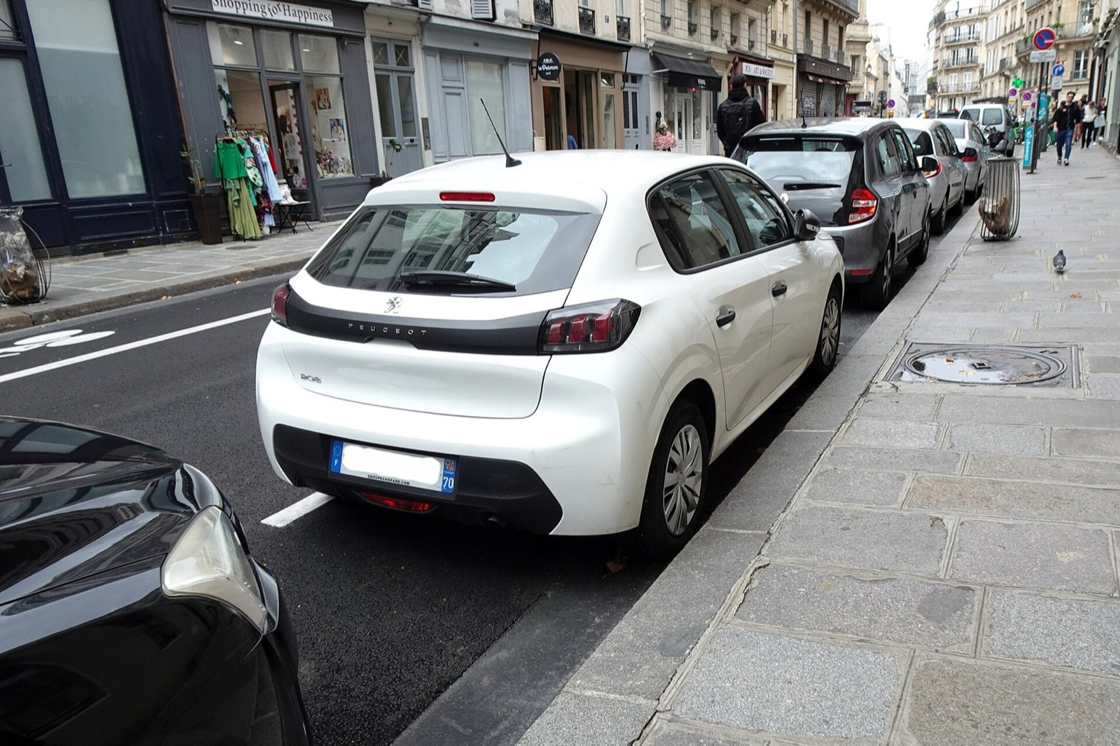Peugeot 208 essence garée dans une rue de Paris